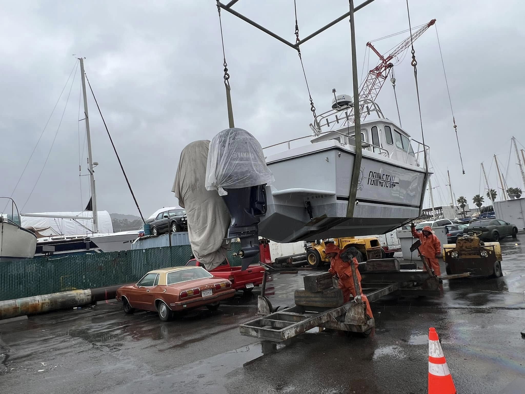 Fishing Team vessel being crane-launched in the rain