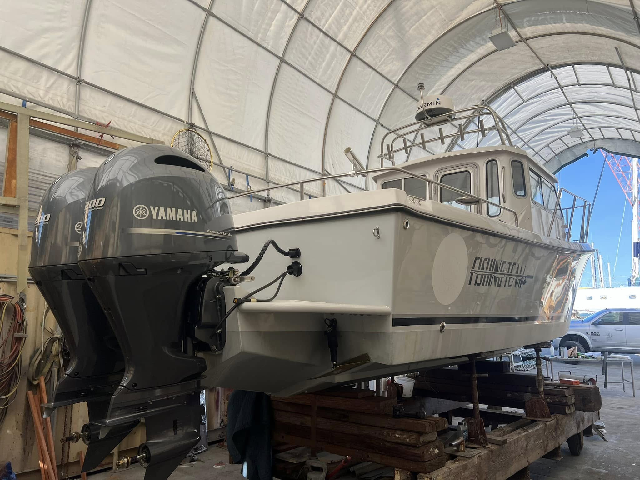 Fishing Team vessel with dual Yamaha 200 outboards in covered bay